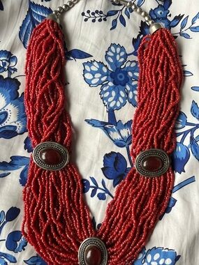 A multi-strand coral seed bead necklace with sterling silver accents.